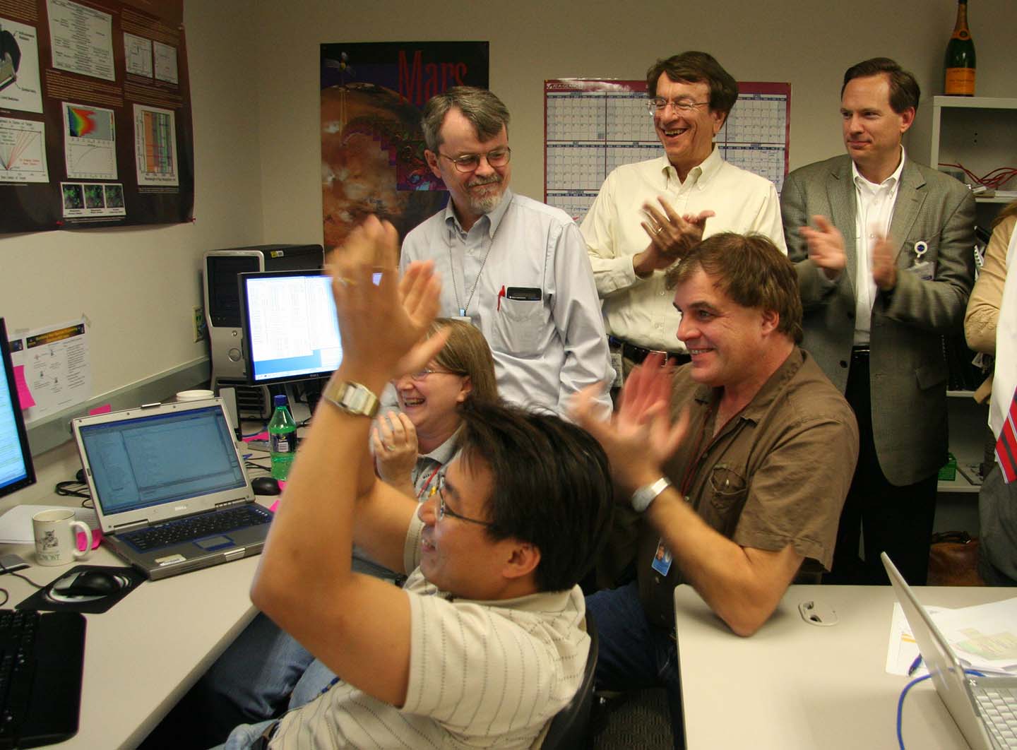 CRISM team members celebrate upon hearing that CRISM's protective cover had opened