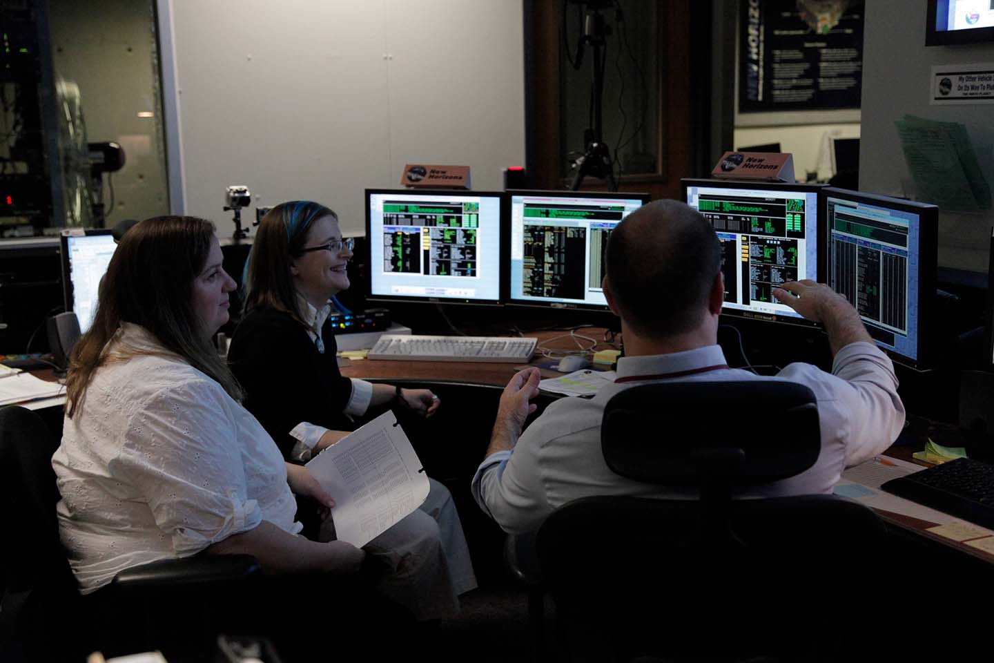 New Horizons flight controllers Sarah Bucior, Katie Bechtold and George Lawrence monitor data