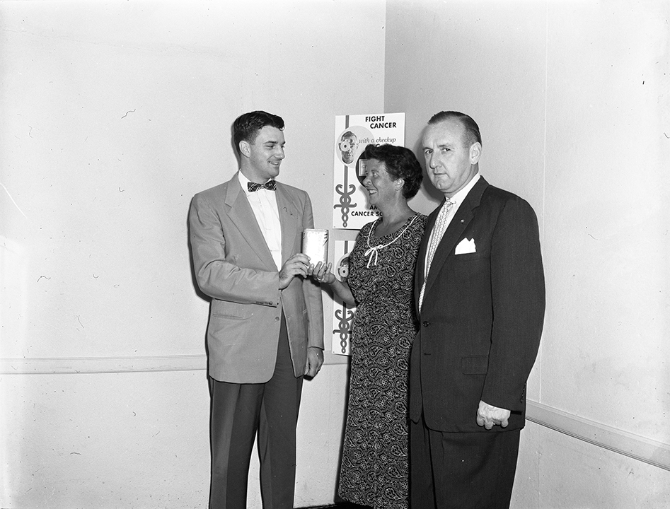 Mrs. Helen D. Sherbert, right, hands over her private mite box to Lawrence B. Maloney, Jr., local business and trades chairman of the American Cancer Society drive (1956)
