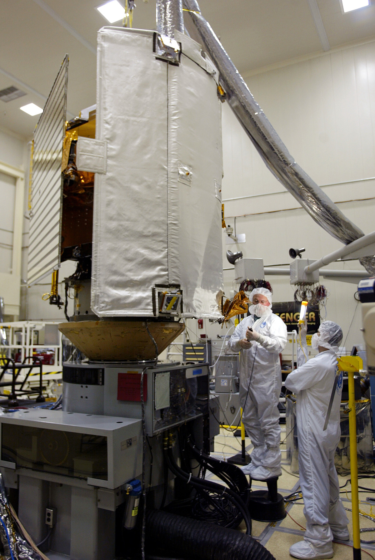 MESSENGER team members adjust the Mercury-bound spacecraft's ceramic-fabric sunshade