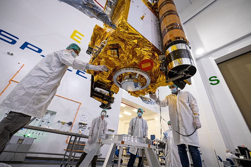 DART team members carefully lower the DART spacecraft onto a low dolly in SpaceX’s payload processing facility on Vandenberg Space Force Base.