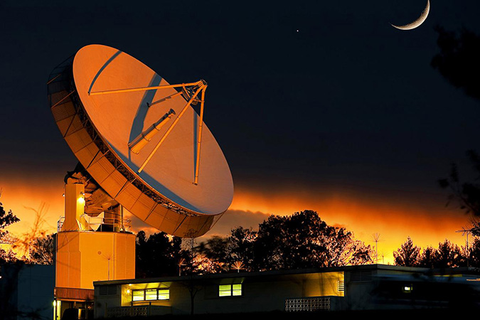 Johns Hopkins APL's 60-foot dish antenna illuminated at night