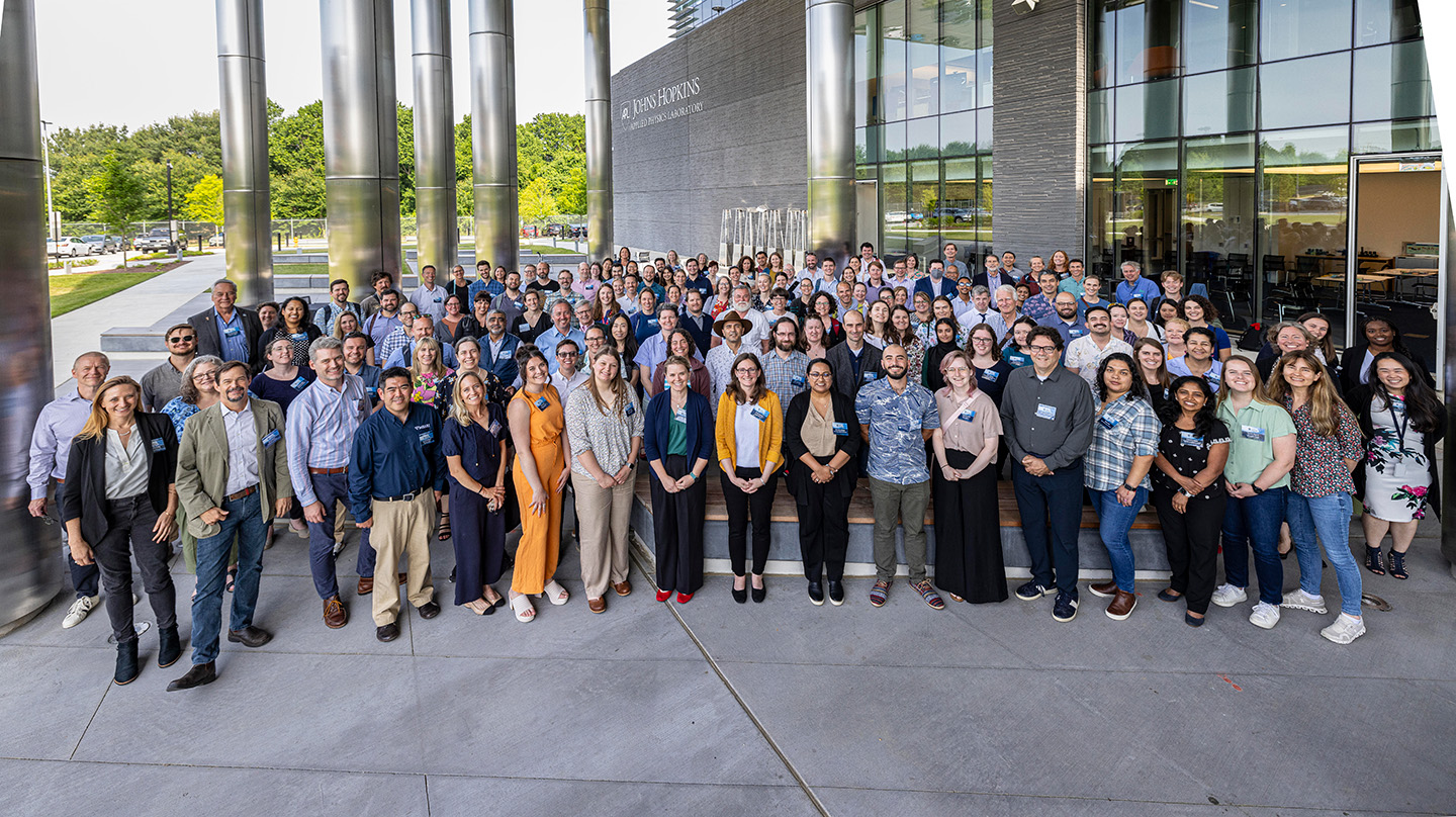 Workshop participants who attended in person gathered on APL’s campus for a group photo.