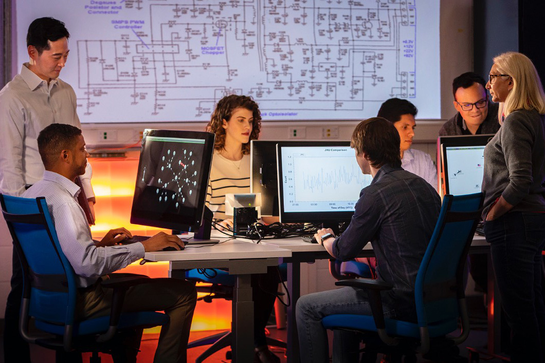 A group of APL staff members work together in a computer lab