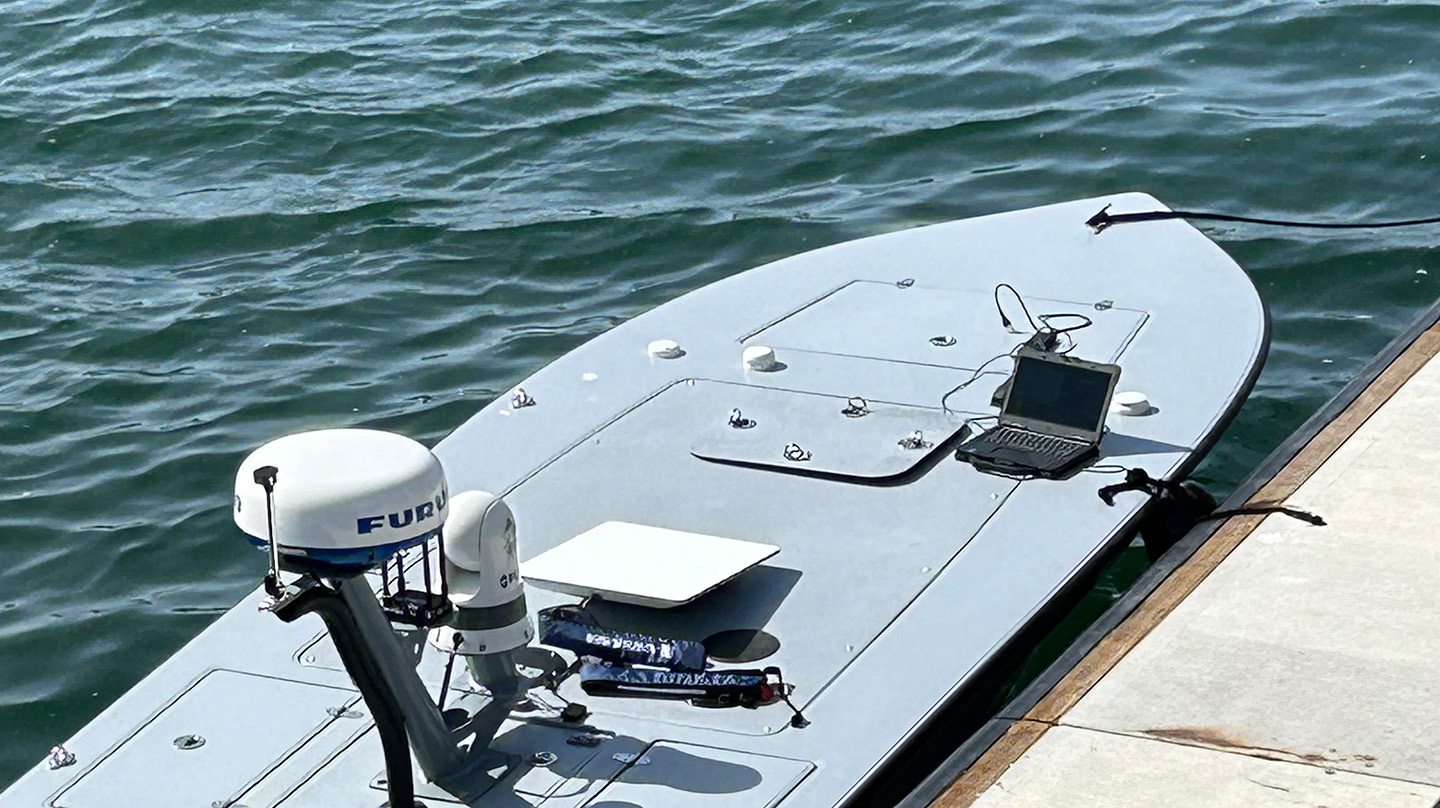 A MARTAC M-18 uncrewed surface vessel moored to a pier in San Diego.