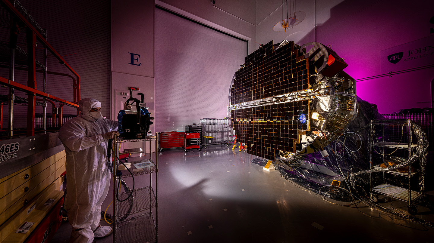 Andrew Gerger uses a test lamp to illuminate the solar panels for testing on the Interstellar Mapping and Acceleration Probe at Johns Hopkins APL.