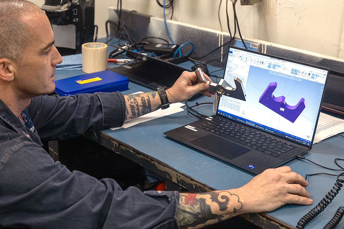 Machinery Repairman 1st Class Cory Hover demonstrates the software used to design the sprayer plate used to cool, lubricate and maintain oil pressure for the Wasp-class amphibious assault ship USS Bataan’s (LHD 5) #4 de-ballasting air compressor. 