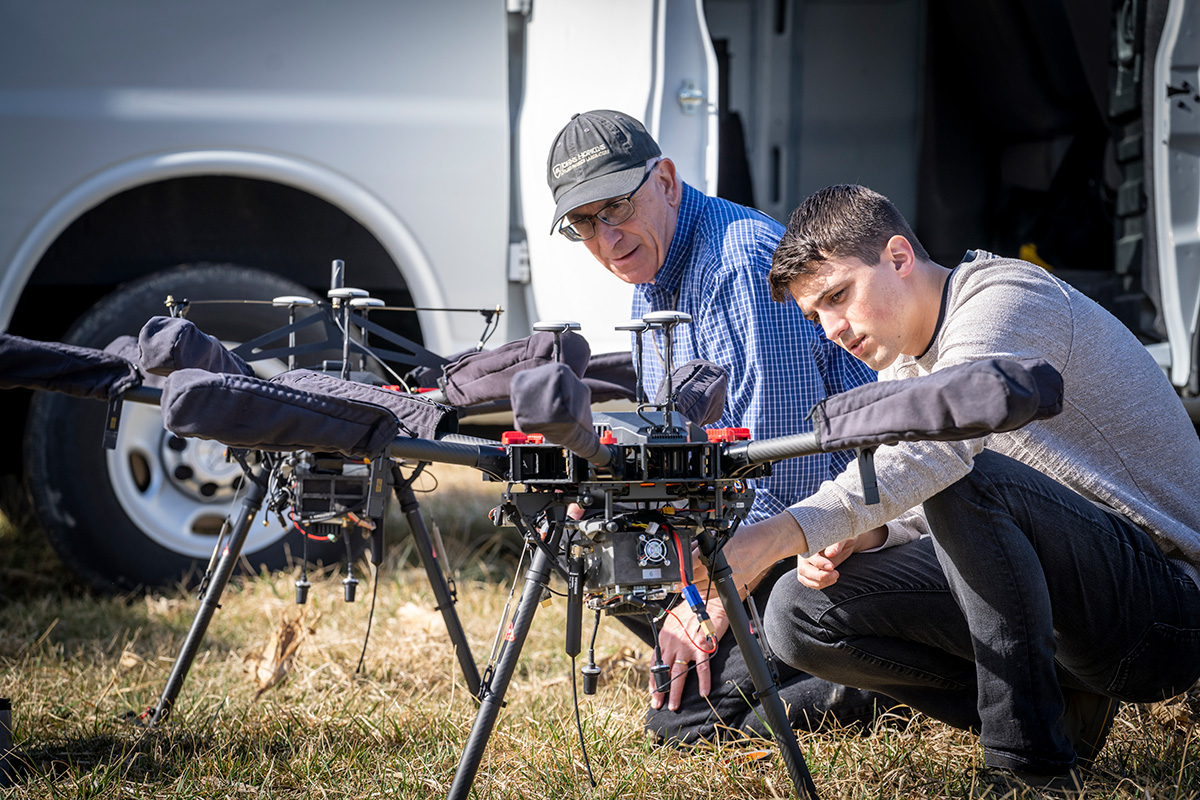 Two APL researchers collaborate during an off-site demonstration