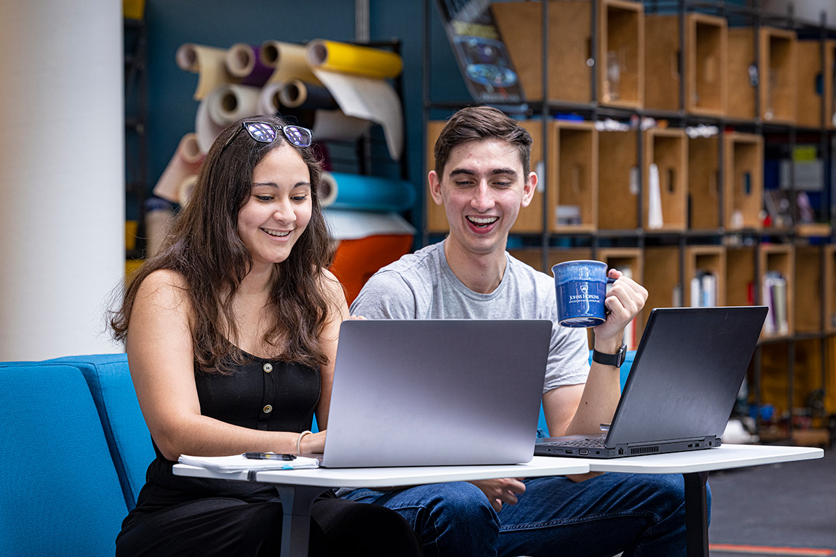 Two APL interns discuss work at their computers