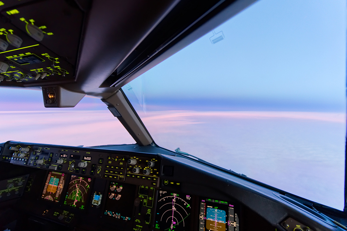 View of twilight from cockpit of a plane, with instrument panel in foreground (Credit: Bigstock)